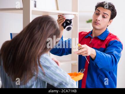 The client getting securty camera installed at home by contractor Stock Photo