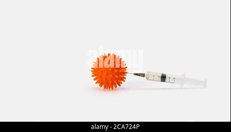 Injection of the vaccine in a cell model of a coronavirus on a white background. The concept of protection and prevention against covid-19. Copy space Stock Photo