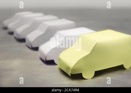 Tiny paper cars lined up.