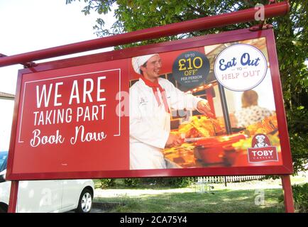 A large roadside sign is seen outside a Toby Inn Carvery informing people of their participation in the Eat In to Help Out Scheme.Pub Restaurants which have declared themselves as participating in the UK government's 'Eat Out to Help Out Scheme'. Diners receive a 50% discount, up to £10 each, on food or non-alcoholic drinks every Monday, Tuesday and Wednesday during August.  The scheme is to help boost the ailing hospitality industry which has been hit hard during the worldwide coronavirus pandemic. Stock Photo