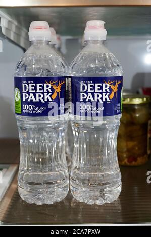 Plastic Deer Park spring water bottles on a refrigerator shelf. Stock Photo