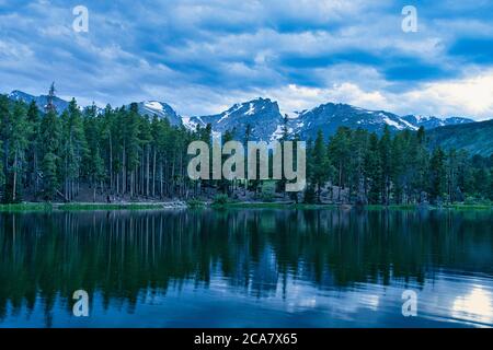 Sprague lake at sunset. Cold scene in rocky mountain national park colorado. Snow capped peaks visible and reflecting off lake surface. Beautiful and Stock Photo