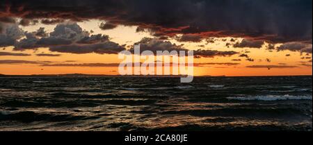 dramatic sunset over the stormy sea Stock Photo