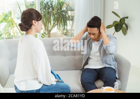 Famale psychiatrist listening to her patient who experienced traumatic events Stock Photo