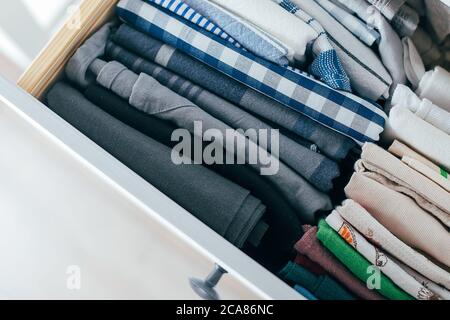 Close up stack of folded kitchen towel in a closet drawer in natural light. Room cleaning, tidying up and Space organization concept. Top view. Zero w Stock Photo