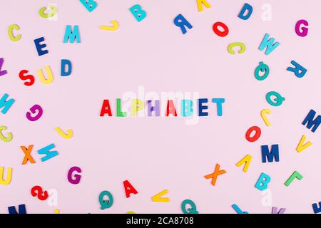Bright multicolored alphabet background with word "Alphabet". Flat Lay, Copy space, top view. Stock Photo