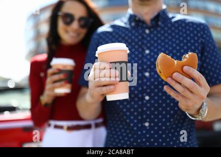 Man and woman are holding coffee and hamburger Stock Photo
