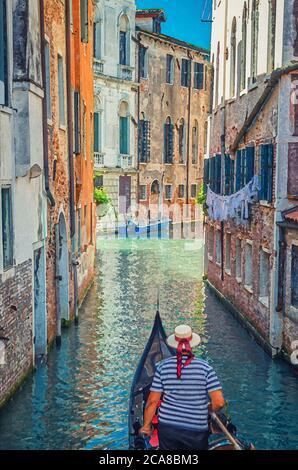 Watercolor drawing of Gondola sailing narrow canal in Venice between old buildings with brick walls. Gondolier dressed traditional clothes and boater straw hat with red ribbon. Stock Photo