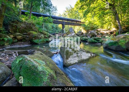 Wooden roofed bridge over the Irreler Waterfalls, rapids in the lower reaches of the Prüm between Prümzurlay and Irrel, in the Eifel district of Bitbu Stock Photo