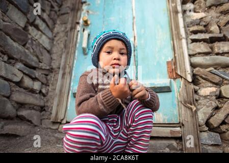 Xinaliq / Azerbaijan - July 8, 2019: portrait of little boy with woolen hat on streets of stone houses village Stock Photo