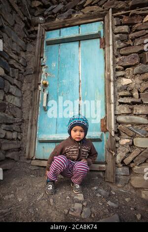 Xinaliq / Azerbaijan - July 8, 2019: portrait of little boy with woolen hat on streets of stone houses village Stock Photo