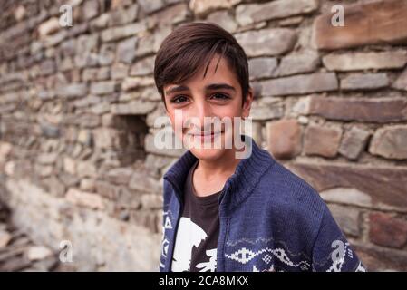 Xinaliq / Azerbaijan - July 8, 2019: portrait of boy on streets of stone houses village Stock Photo