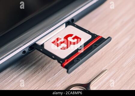 SIM card labeled 5g. Replacing a SIM card in mobile phone with high-speed Internet. Stock Photo
