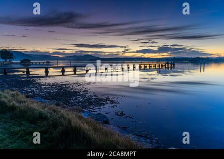 Sunrise waterscape with wharf, high cloud and reflections at Woy Woy Waterfront on the Central Coast, NSW, Australia. Stock Photo