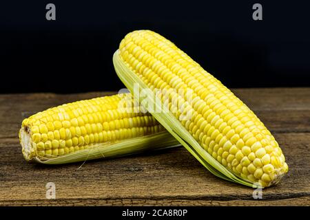Close up fresh sweet corn on wooden table background. Stock Photo