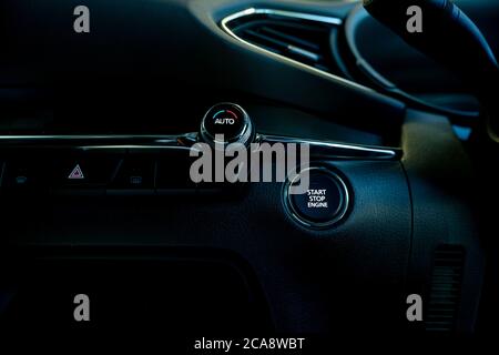 Start stop engine button of luxury car. Push up button for start or stop car engine in keyless automobile. Turn key with ignition system concept. Stock Photo