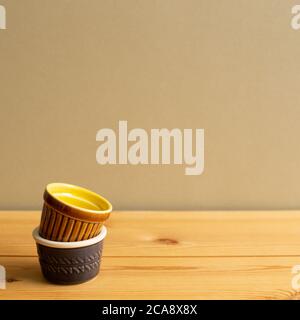 Stack of ceramic bowls on wooden table with brown background Stock Photo