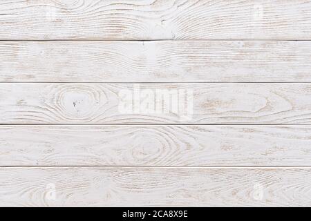 Surface of textured wood planks painted with white paint. Empty background of horizontal white wood boards. Rustic tabletop pattern for design. Stock Photo