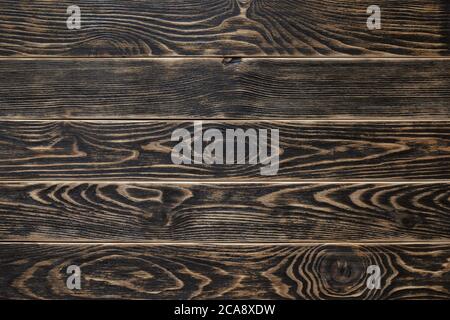 Surface of textured wood planks painted with black paint. Empty background of horizontal wood boards. Rustic tabletop pattern for design full frame. Stock Photo