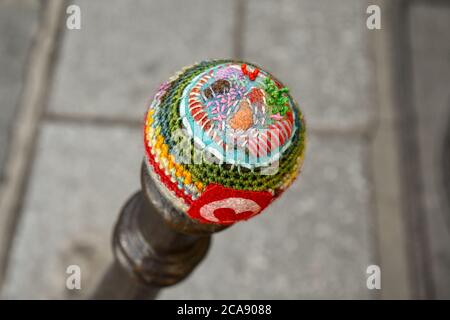 Close-up of the top of a bollard covered with a colorful crochet fabric (yarn bombing) in a street of the Marais district, Paris, France Stock Photo