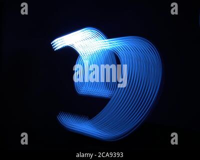 Beautiful graphic shapes made of light with a long exposure. Background pattern in shades of classic blue color of the year 2020. Stock Photo