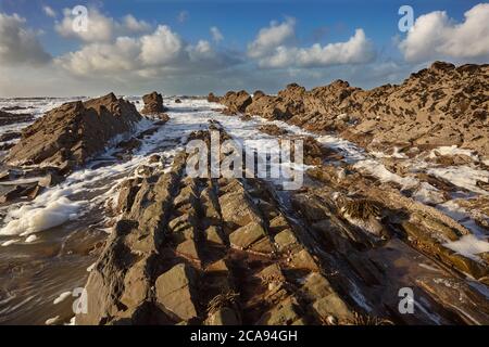 Surf rolling onto a rocky Atlantic shore, at Widemouth Bay, near Bude, Cornwall, southwest England, United Kingdom, Europe Stock Photo