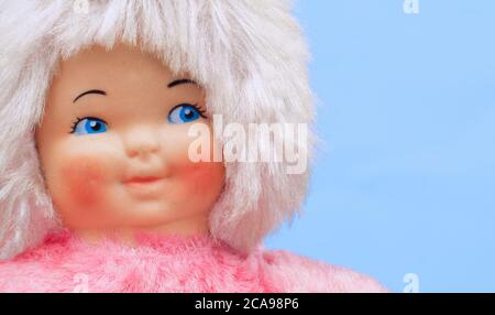 Child's doll on blue close up with copy space Stock Photo