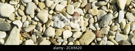 Baltick Sea beach. Natural small pebbles on the rocky seashore, panorama. can be usedas texture or backround. Stock Photo