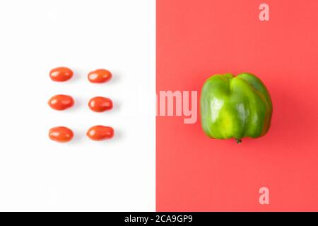 Creative layout made of pepper and cherry tomato on colorful red background. Pop art design, summer food concept. Healthy food minimal flat lay. Stock Photo