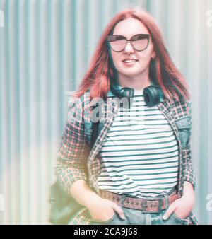 Glitched portrait of a beautiful modern smiling young female teenager with extraordinary hairstyle color in a checkered shirt and mirrored sunglasses Stock Photo