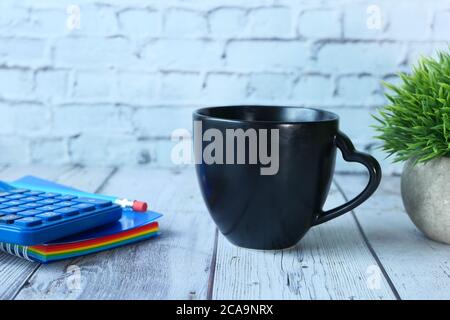 Black mug mockup with with keyboard, notebooks on table  Stock Photo