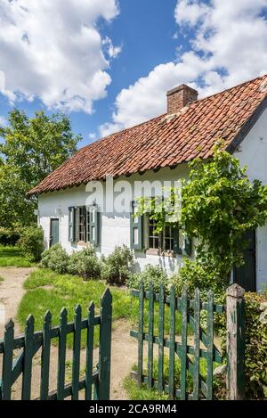Wooden fence and 19th century rural day labourer's house / farm laborer's home Kortessem at the open air museum Bokrijk, Limburg, Flanders, Belgium Stock Photo
