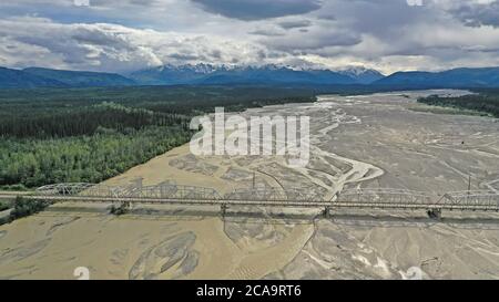 The Alaska Range of mountains loom in the distance over the Tanana River Stock Photo