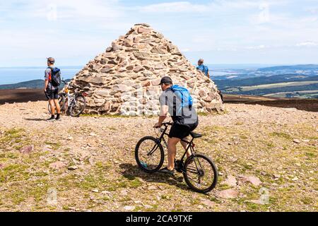 Exmoor National Park - Mountain bikers enjoying the view from the cairn marking the highest point on Exmoor, Dunkery Beacon 1705 feet 520 metres, Some Stock Photo