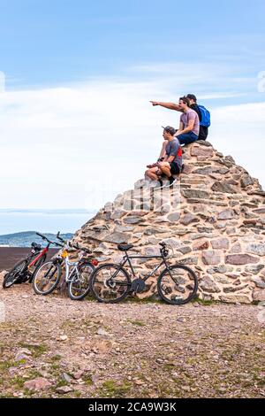 Exmoor National Park - Mountain bikers enjoying the view from the cairn marking the highest point on Exmoor, Dunkery Beacon 1705 feet 520 metres, Some Stock Photo