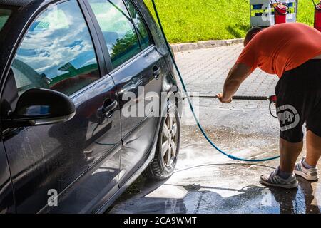 Washing and cleaning car in self service car wash station. Car washing using high pressure water in Bucharest, Romania, 2020 Stock Photo