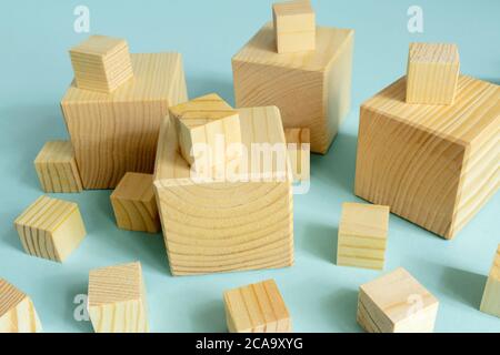 many wooden cube of different size on blue background. Construction and developing consept. mockup for designers Stock Photo