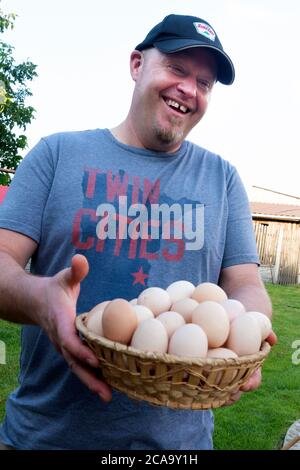 Happy man holding a basket of farm fresh eggs purchased from a local farmer. Zawady Gmina Rzeczyca Poland Stock Photo
