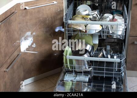 Clean utensil in dishwasher. Washed dishes, plates, cups, jars, mugs, cutlery, pots. Concept of hygiene, household, home care, water saving, helpers i Stock Photo