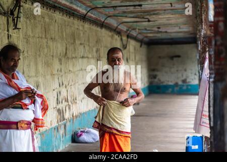 Mayiladuthurai, Tamil Nadu, India - February 2020: An elderly Indian temple priest with long white beard in traditional attire inside the ancient Hind Stock Photo