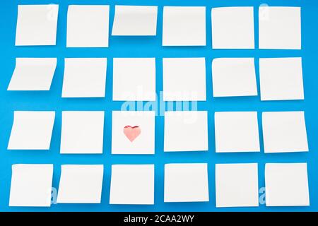 Lots of blank yellow eidin stickers with hearts on blue background. View from above Stock Photo