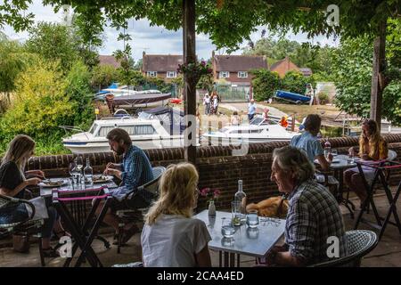 People siting on the riverside terrace overlooking Great Stour river eating al fresco at the Fordwich Arms, Fordwich, Kent, England, United Kingdom Stock Photo