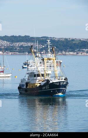 Brixham Trawler BM55 ANGEL EMIEL returning to port Large seagoing trawlers moving around in Brixham harbour Frontal view Calm sea and light blue sky Stock Photo