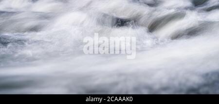 Long exposure photo - water flowing over rocks everything smooth, only few waterdrops in focus Stock Photo