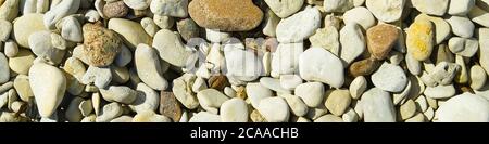 Baltick Sea beach. Natural small pebbles on the rocky seashore, panorama. can be usedas texture or backround. Stock Photo