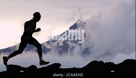Running man athlete trail running in mountain summit background. Male runner on run training outdoors living active fit lifestyle. Silhouette at Stock Photo