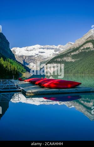 Red canoes on dock, Lake Louise, Banff National Park, Alberta Stock Photo