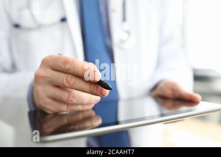 Doctor making notes on graphics tablet close up Stock Photo