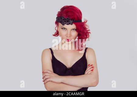 Portrait of unhappy angry woman standing with arms folded. Red head curly bob hairstyle girl isolated light gray grey white background. Mixed race lat Stock Photo