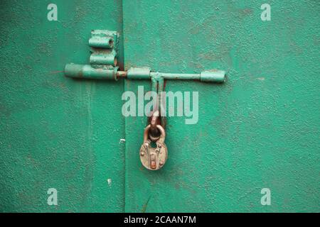 Handing padlock on green garage door. Security concept Stock Photo